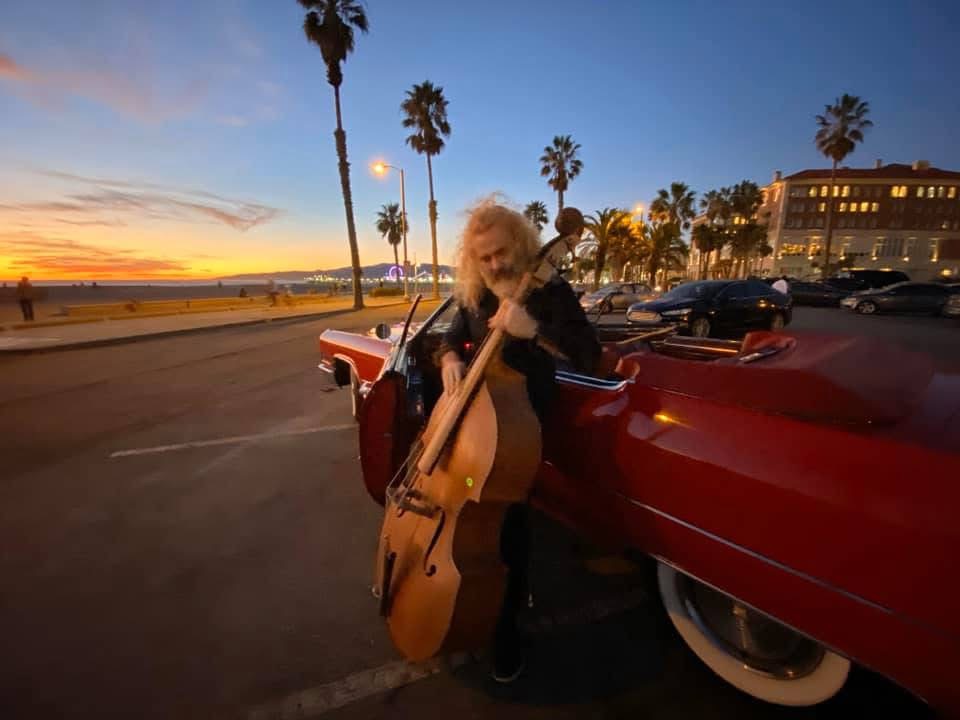 Gaz Williams with a double bass beside a classic red car